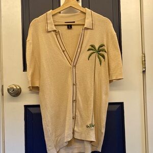 Art of Rhetoric knit polo with a palm tree on the side.